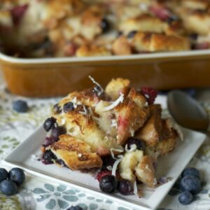 A serving of Blueberry Coconut Bread pudding on a white plate
