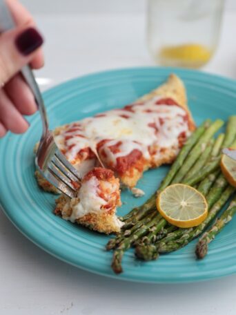 Baked Chicken Parmesan with asparagus on a plate
