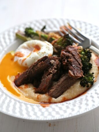 Cheesy Polenta with Steak and Poached Eggs on a plate