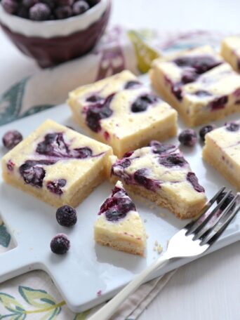 Blueberry Orange Cheesecake Bars on a plate with a fork