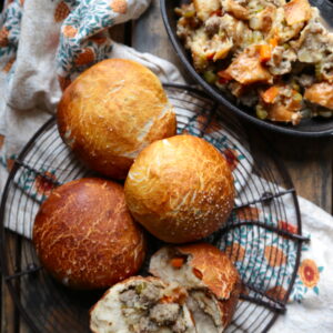 It's a roll, it's Thanksgiving stuffing! No, it's Thanksgiving stuffing stuffed pretzel rolls! These sausage sour dough stuffing filled pretzel rolls are the best of two worlds at your turkey day table.