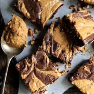 Chocolate Peanut Butter Brownies with Pretzel Crust - The ultimate brownie with swirled peanut butter and a sweet and salty pretzel crust! This easy dessert recipe will have you eating them out of the pan!