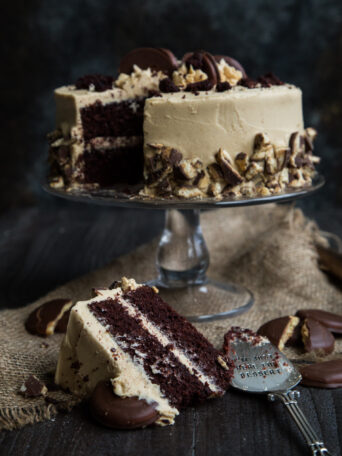 Chocolate Fudge Cake with Peanut Butter Whipped Buttercream - Tagalong Girl Scout Cookie Cake on a cake stand with dark background and burlap napkin