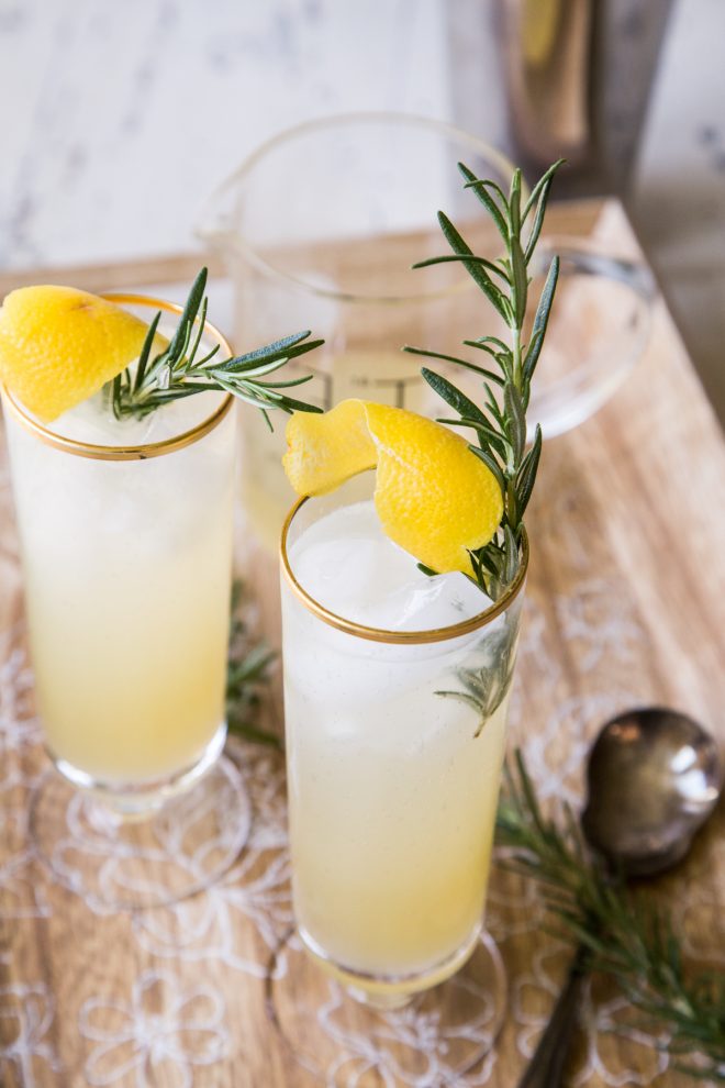Homemade Rosemary Lemonade Spritzer Cocktail with tall gold rim glasses