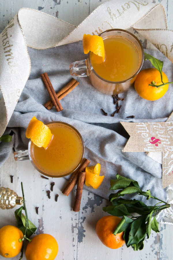 Orange Spiced Apple Cider with oranges cloves and ribbon