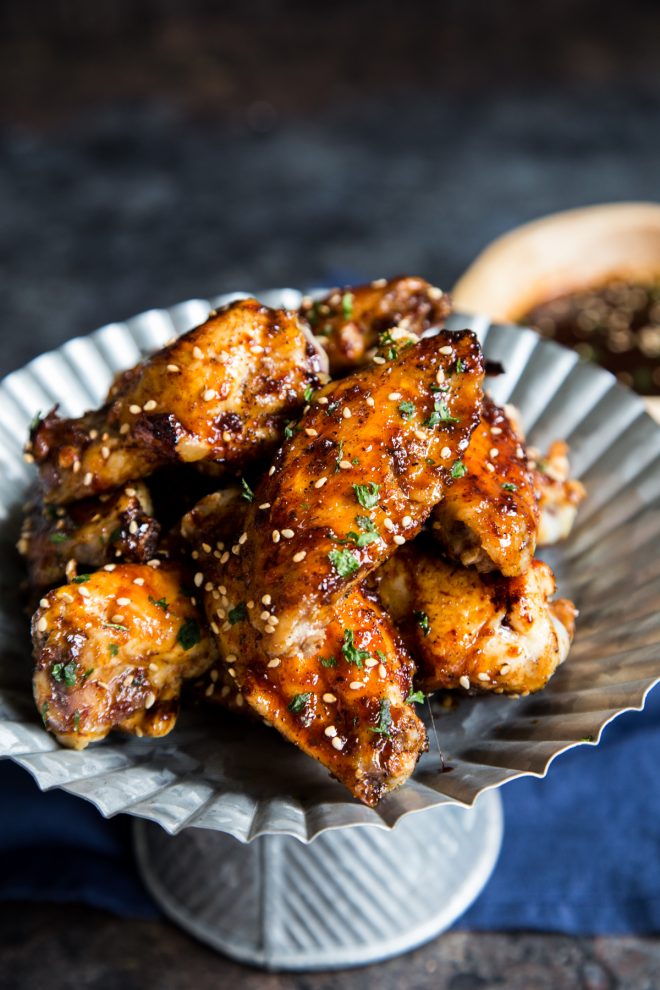 plate of chicken wings on a metal stand with a dark background