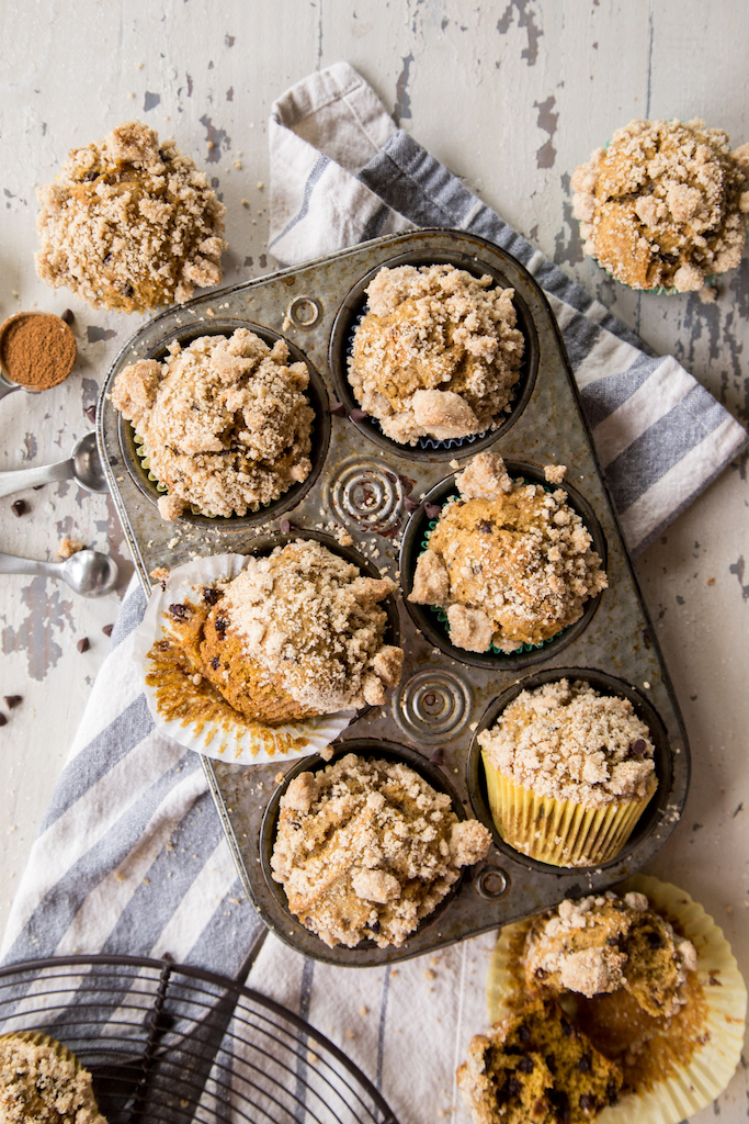 Pumpkin muffins in a antique metal tin on a white board background