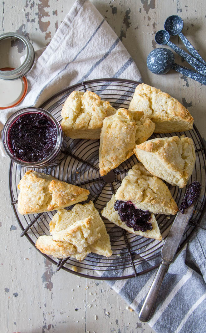 homemade blueberry butter is a great beginner's recipe to canning, and a zero waste recipe. Pictured here with cream scones on a wire rack.
