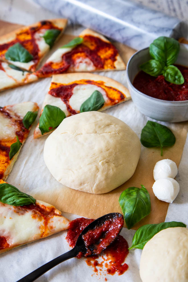 no fuss five minute pizza dough, dough ball surrounded by cut pizza margarita 