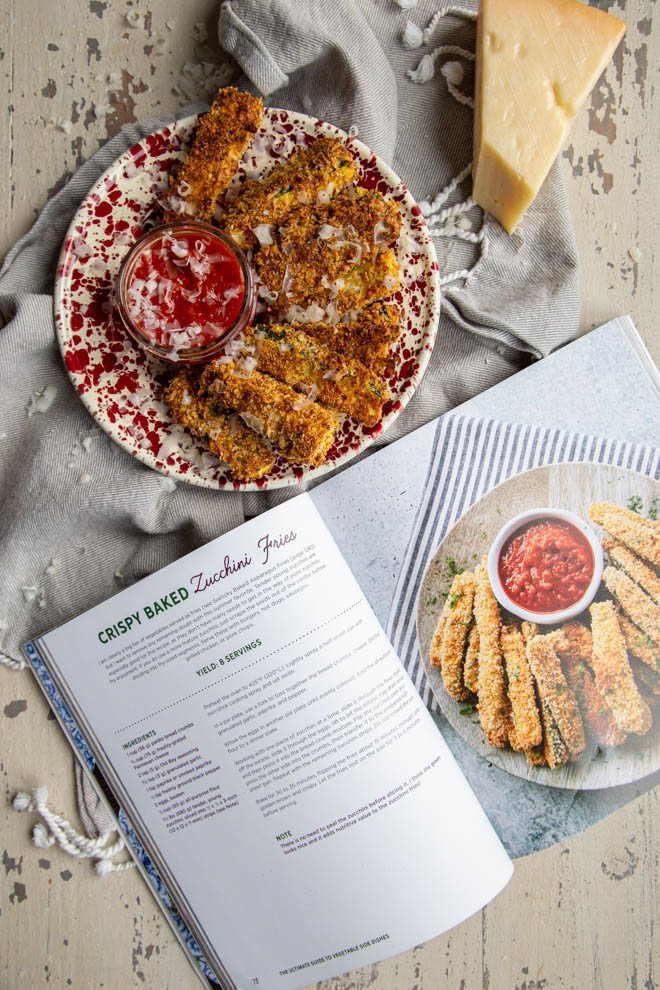 crispy baked zucchini fries on a red plate with cookbook shot from overhead