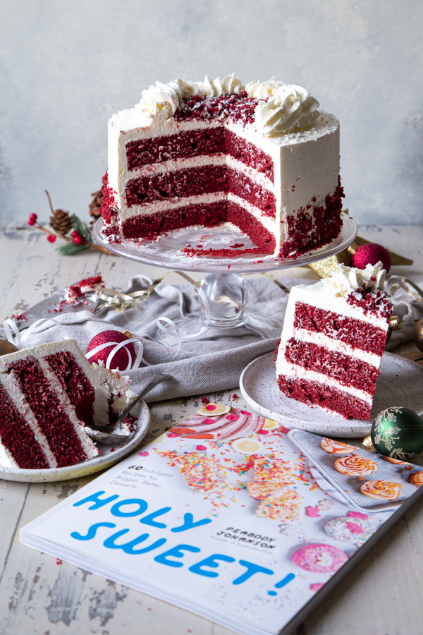 Sliced red velvet peppermint cake with Holy Sweet! cookbook in foreground