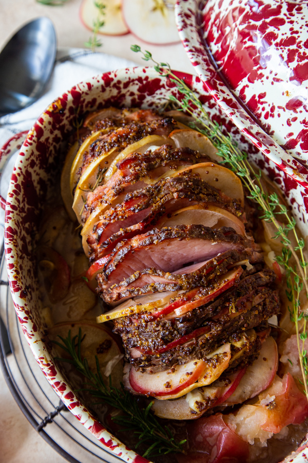 Overhead shot of Roasted Ham With Honey Mustard Glaze and Apples in roasting dish