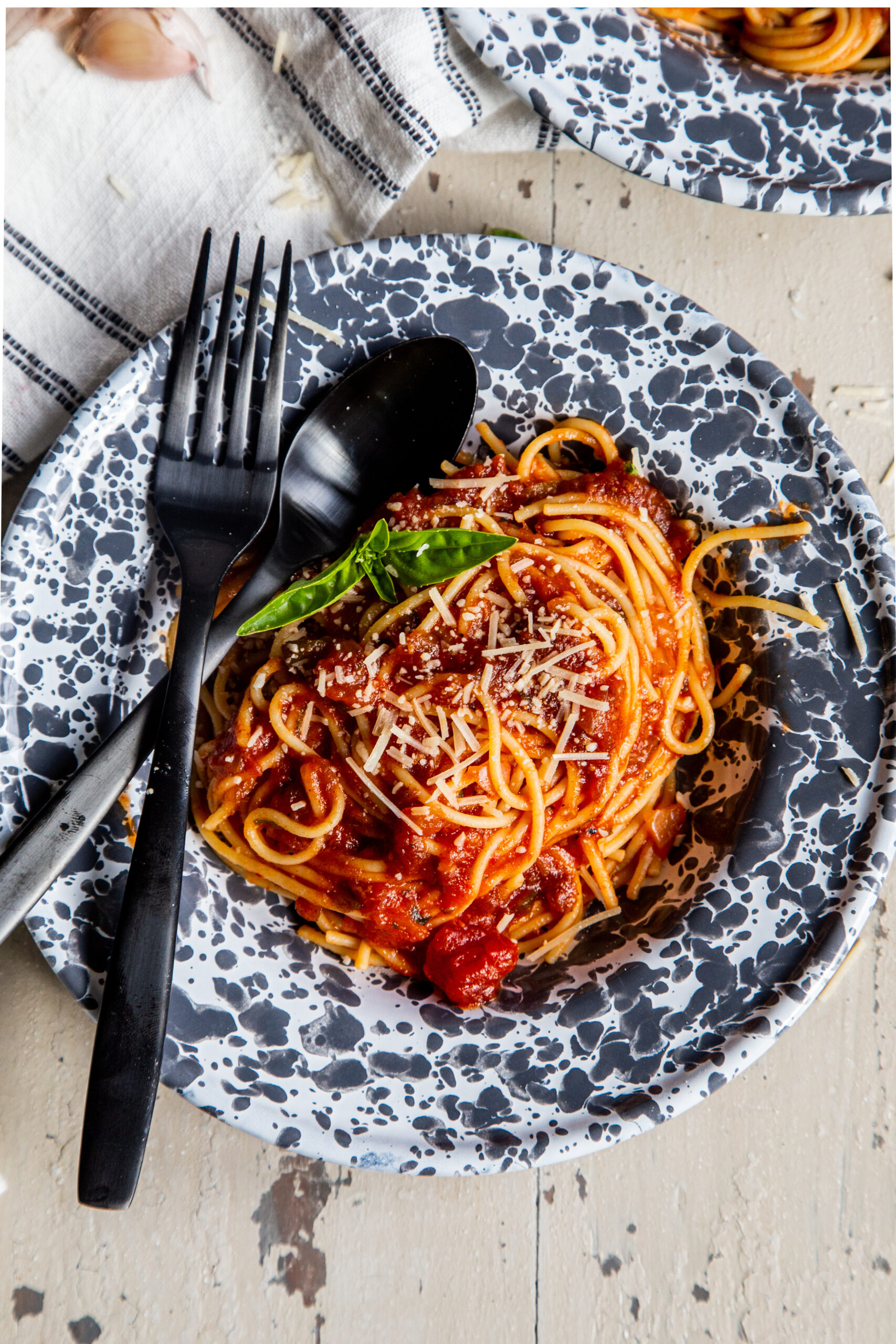 Overhead shot of bowl with spaghetti and pasta sauce with fork and spoon