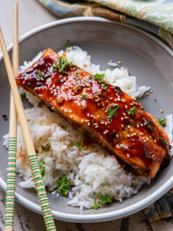 Teriyaki Herb Glazed Salmon Fillets over white rice with chopsticks