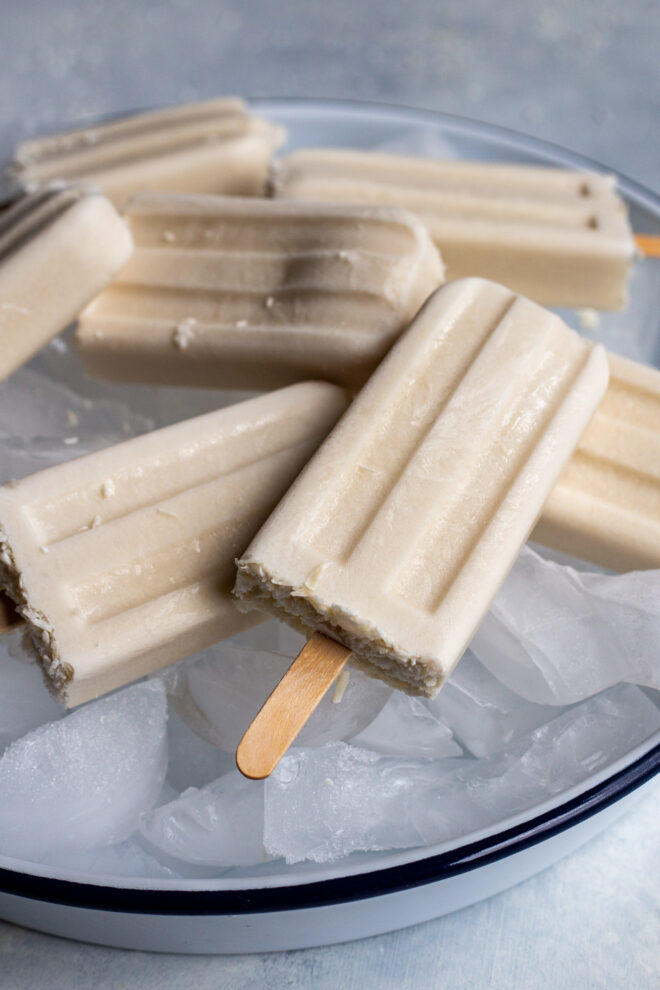 Vegan coconut paletas on a bowl of ice and white background, Photo taken close up to see texture