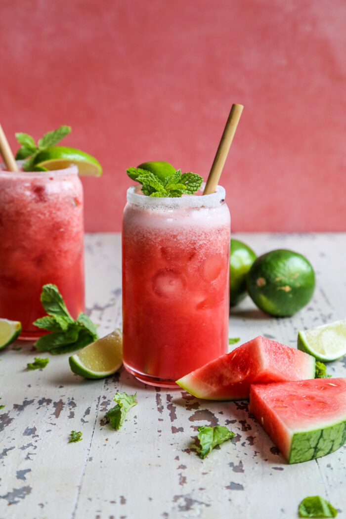 Watermelon guava agua fresca with sliced watermelon and lime on a white farmhouse background