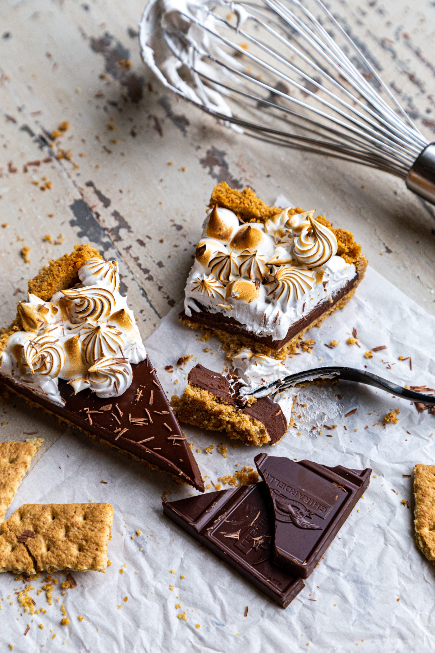 Two slices of Chocolate S'mores Tart with chopped chocolate and graham crackers 