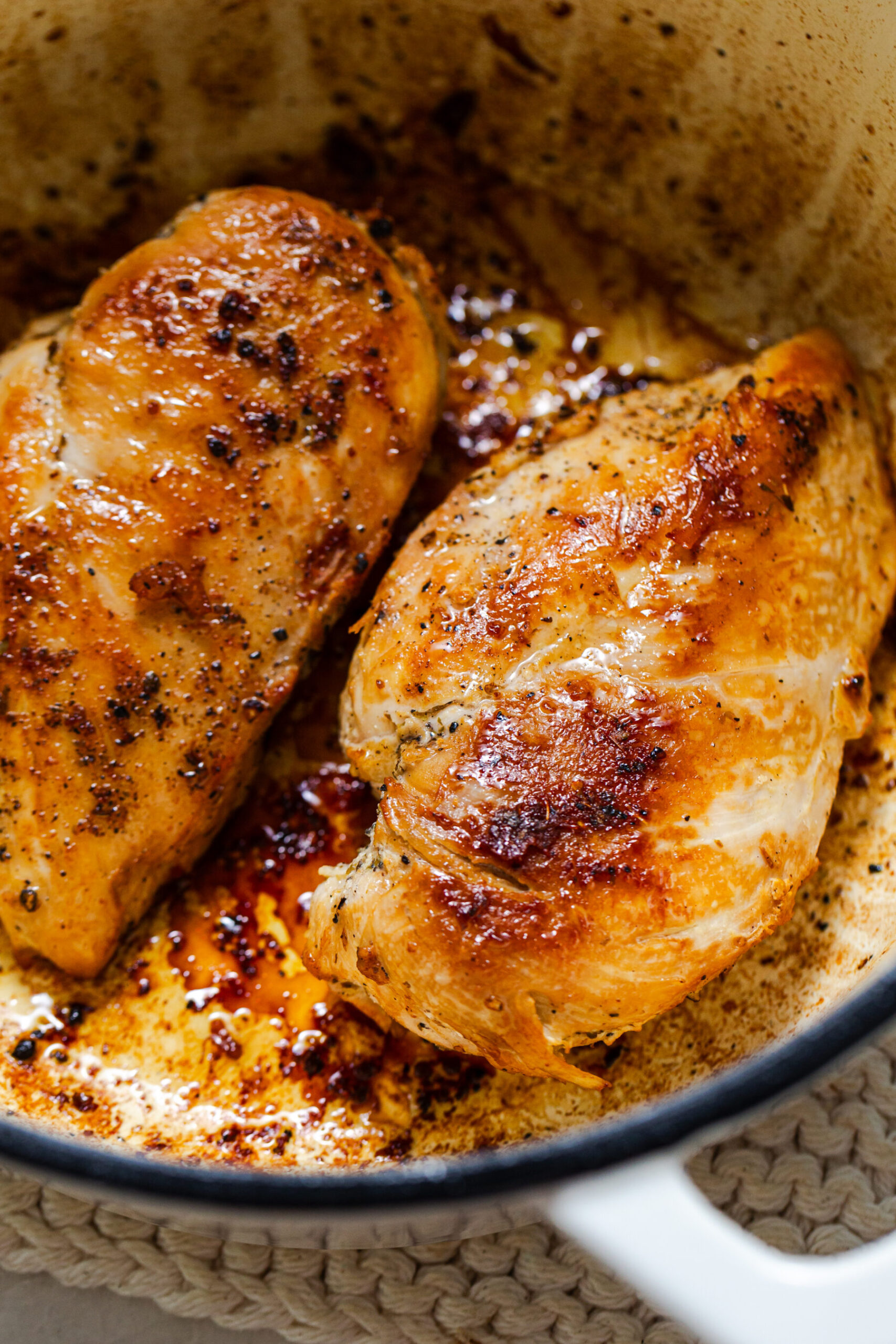 Close up of seared chicken breasts in a cast iron pan for one pot chicken florentine pasta