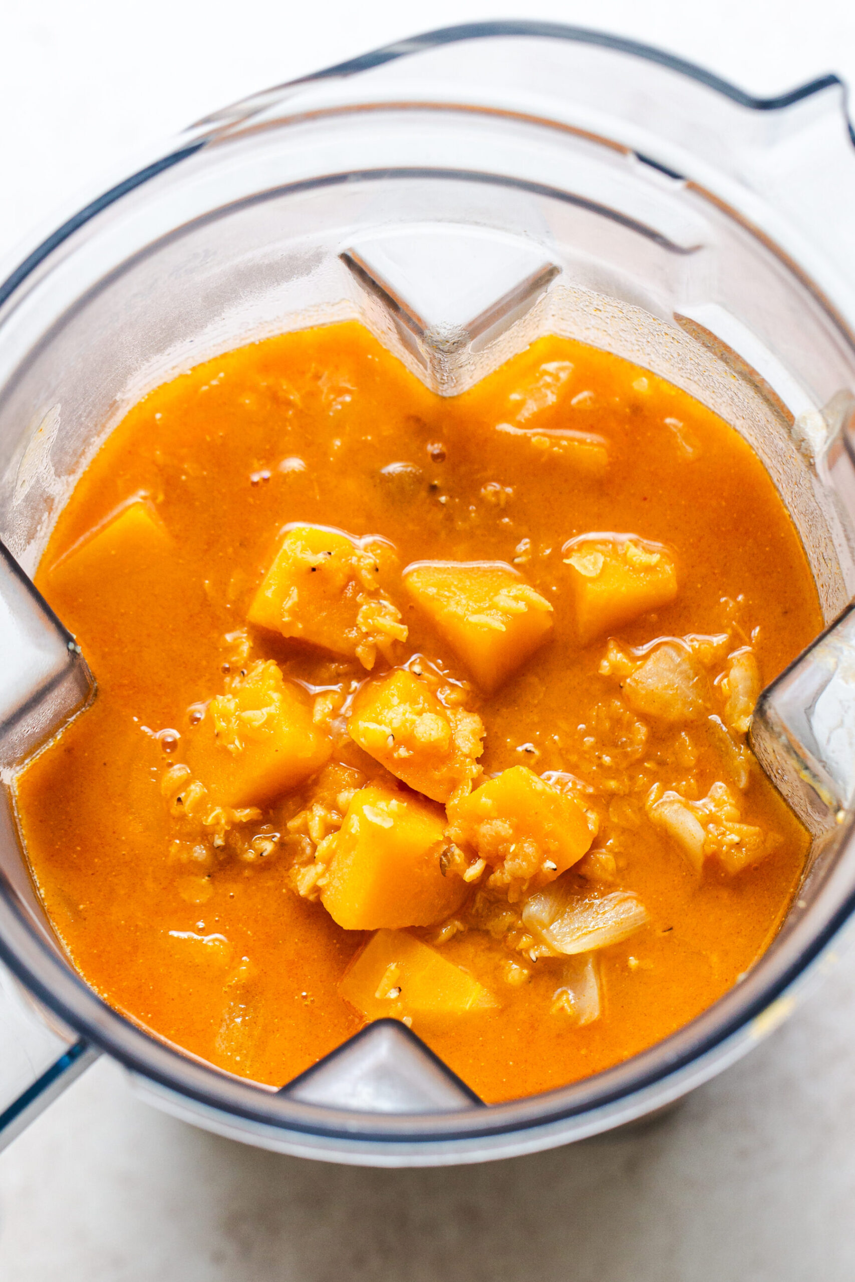 Butternut squash soup in a blender before being blented smooth. Photo from directly overhead. 